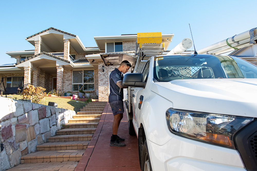 Image of one of our Booroobin plumbers grabbing tools from the van